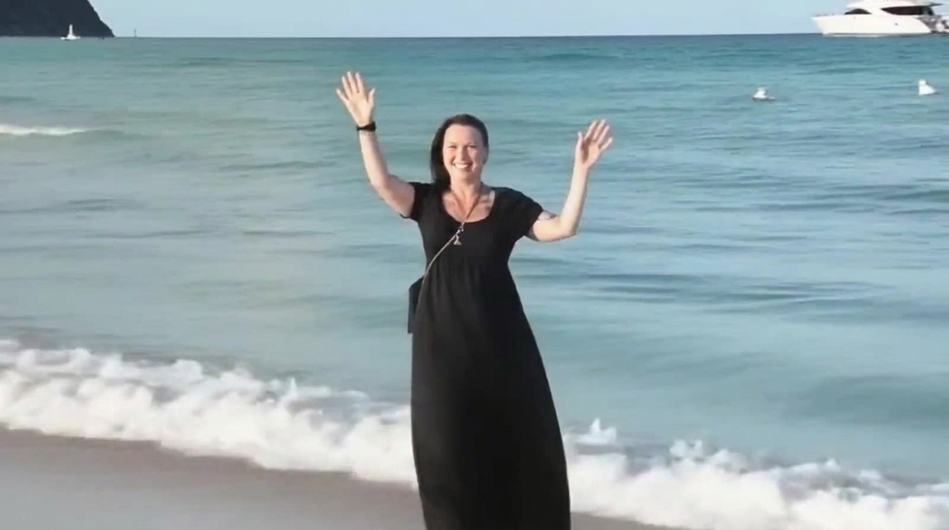 Frau sitzt entspannt am Strand bei Sonnenuntergang – ein stiller, authentischer Moment